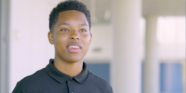 A pre-college student smiles.